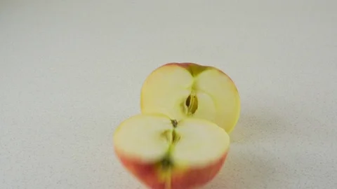 A large apple falls onto a table and breaks into two. Vídeo Stock 116598784