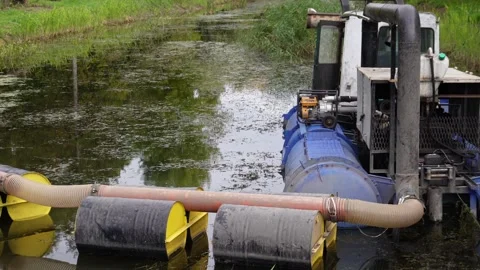 A large aquatic maintenance machine with blue floats is actively clearing t.. Stock Footage 321918302