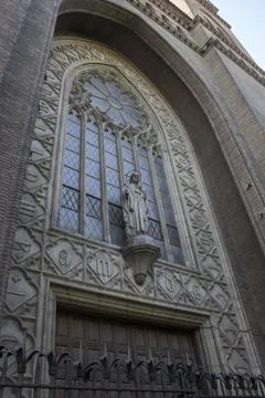 A large arched window in an ancient building with a statue Stock Photos