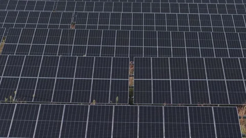 A large array of photovoltaic solar panels arranged across a solar farm for Video stock 342777333