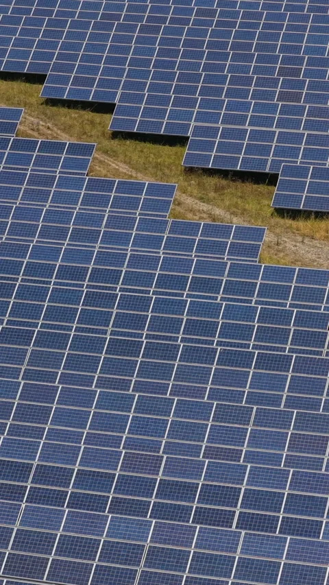 Large Array Of Shiny Blue Solar Panels Divided By A Curving Dirt Road In A .. Video stock 338990686