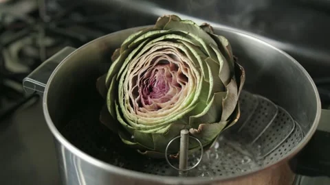 A large artichoke steams in a pot Vídeos de archivo 338159089