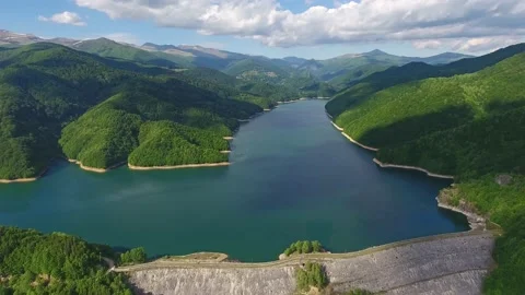 Large artificial lake and dam surrounded by mountains Stock Footage 235124890
