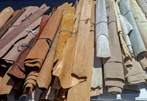 Large assortment of rolled leather hides in brown and neutral tones at outd.. Foto stock