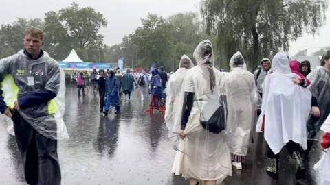 Large audience wearing raincoats during song festival on rainy day Stock Footage 326777786