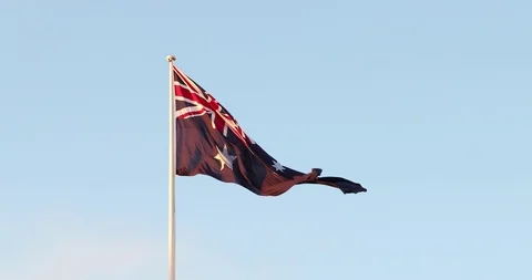 Large Australian flag blows in the wind in slow motion at sunset Stock Footage 94025745