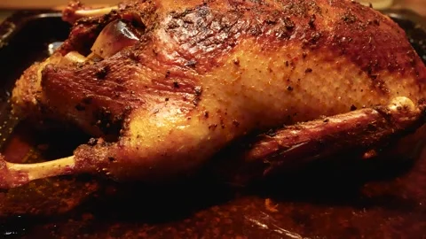 A large baked turkey with a fragrant crust lies on a baking sheet. A dish for Stock Footage 255998290