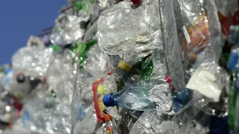 Large bale of crushed plastic bottles for recycling against blue sky Stock Footage 332649615