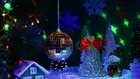 A large ball surrounded by a green house with a bell and a snowman Stock Footage 333641085