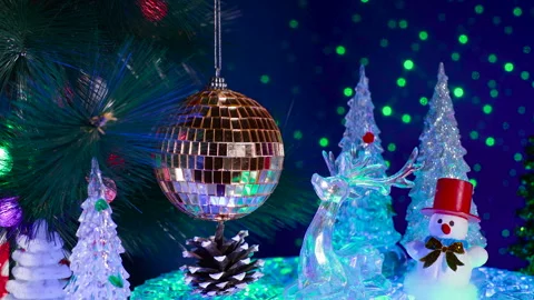 A large ball surrounded by trees, a deer, and a snowman with a pine cone Stock Footage 333640103