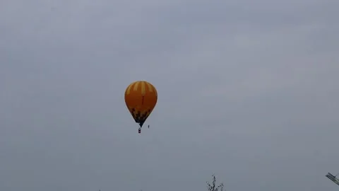A large balloon, brightly colored, flies over the city. Video stock 140512139