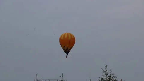 A large balloon, brightly colored, flies over the city. Video stock 140512249