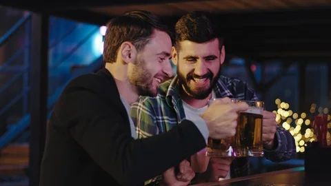 In a large bar good looking guys after the work came to the pub they start to Stock Footage 124470394
