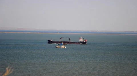 A large barge floating past the small vessel Stock Footage 54928198