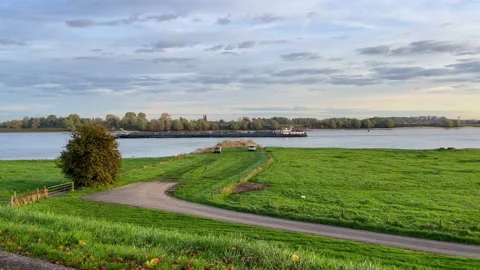 A large barge loaded with cargo sails through a water channel in Netherlands Stock Footage 220221930