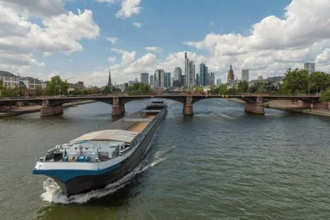 Large barge moving upstream in front of the skyline, Frankfurt, Germany Stock Photos