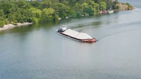 A large barge in summer floats along the river canyon in the background green Stock Footage 138753537