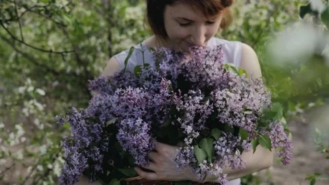 A large basket with garden fresh spring flowers in the hands of a woman. A Stock Footage 196902076