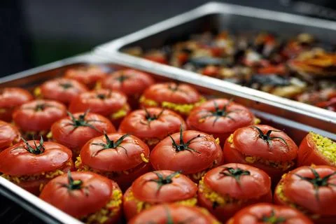 Large batch of rice-stuffed tomatoes in stainless trays Stock Photos