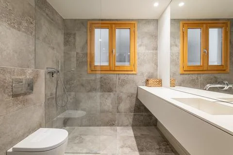 Large bathroom with long vanity unit near washbasin area Stock Photos