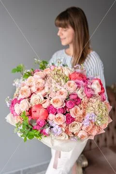 Large Beautiful bouquet of mixed flowers in woman hand. Floral shop concept Stock Photos