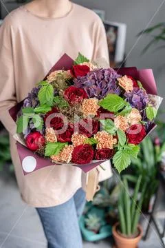 Large Beautiful bouquet of mixed flowers in woman hand. Floral shop concept Stock Photos