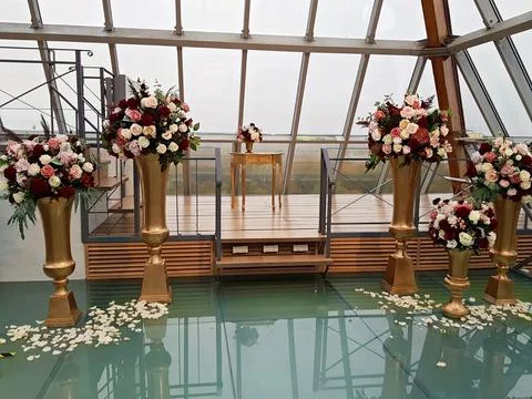 Large beautiful bouquets with different types of flowers in tall gilded vases Foto stock