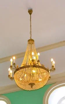 Large beautiful chandelier on the ceiling with candlesticks. Stock Photos