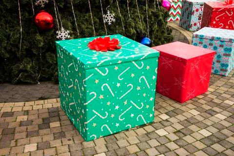 Large beautiful multi-colored gift boxes lie near the Christmas tree Stock Photos