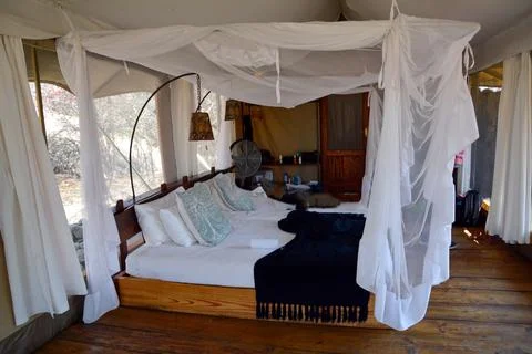 A large bed under a canopy in a bedroom of a hotel or private house Stock Photos