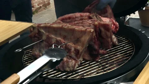 A large beef steak (fiorentina) that makes smoke being cooked in the grill Stock Footage 150576612