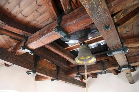 A large bell hangs from the ceiling of a building Stock-Fotos