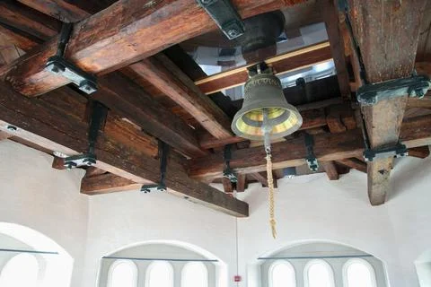 A large bell hangs from the ceiling of a building Foto stock