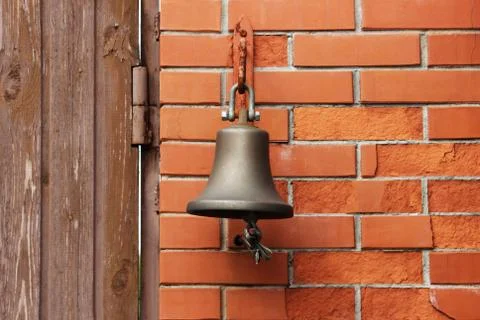 A large bell next to the door, replacing the doorbell. the bell Welcome. Ring Stock Photos