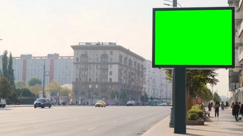 A large billboard with a green screen is positioned high above the street. Video stock 140864669