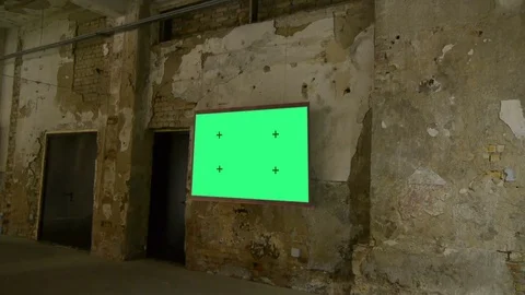 A large billboard hangs on a peeling wall in an abandoned building, green screen Video stock 84253287