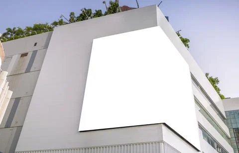 A large billboard installed in the corner of a large building. Stock Photos