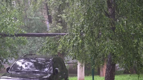 Large black car stands outside in the rain, drops hitting the roof and glass Vidéo 195213401