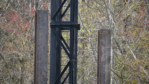 Large Black Metal Section Of A Device Between Two Girders Stock Footage 296025792