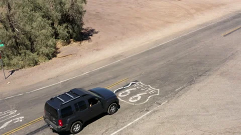 Large black SUV drives over Route 66 paint markings on famous highway Vidéo 146624236