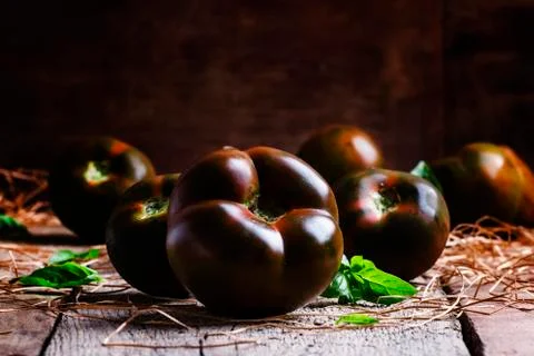 Large black tomatoes, rustic style, selective focus Stock Photos