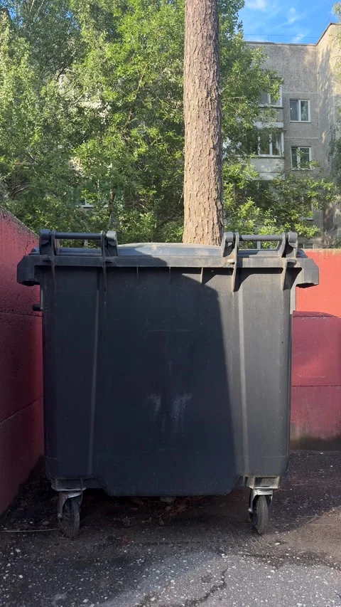 Large black wheeled dumpster for waste collection in residential area Stock-Footage 340998143