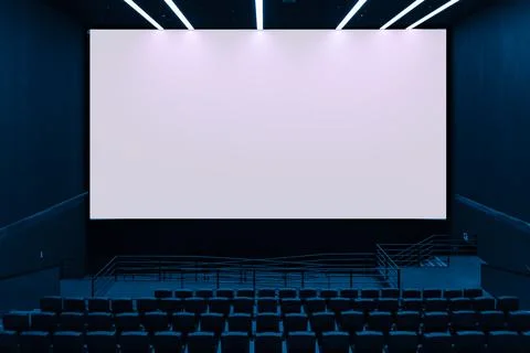 Large blank white cinema screen in dark modern movie theater Stock Photos