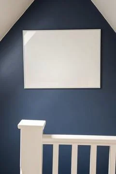 Large blank white horizontal frame on a dark blue wall with a white railing.. Stock Photos