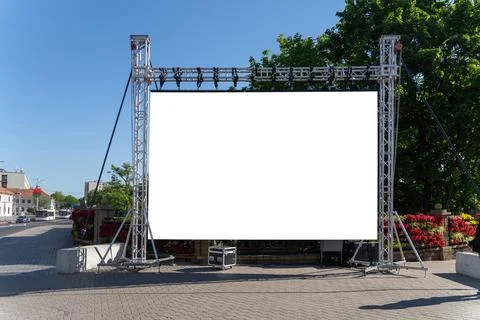 Large blank white screen mounted on metal rigging in a city street. Foto stock