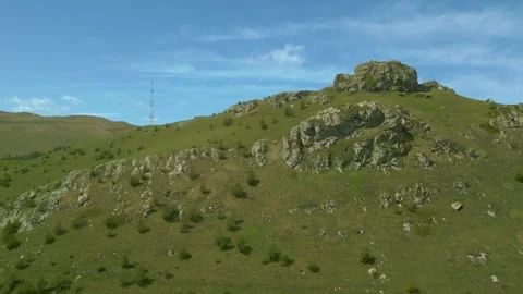 Large block of stone, Wind turbines and antenna. Pushkin Pass Armenia. Video stock 254460470