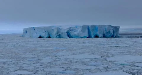 Large blue iceberg at edge of pack ice in antarctic ocean, Antarctica Stock Photos