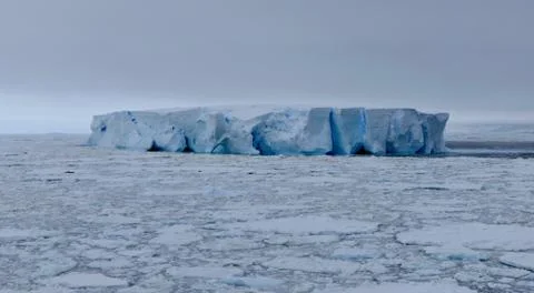 Large blue iceberg at edge of pack ice in antarctic ocean, Antarctica Stock Photos