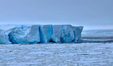 Large blue iceberg at edge of pack ice in antarctic ocean, Antarctica Stock Photos