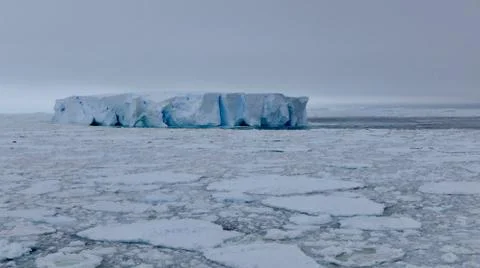 Large blue iceberg at edge of pack ice in antarctic ocean, Antarctica Stock Photos